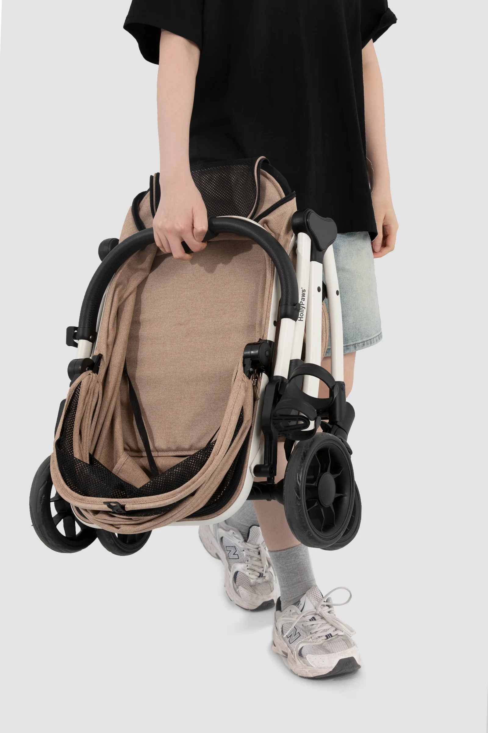 Folded stroller lifted by the frame for a short transfer