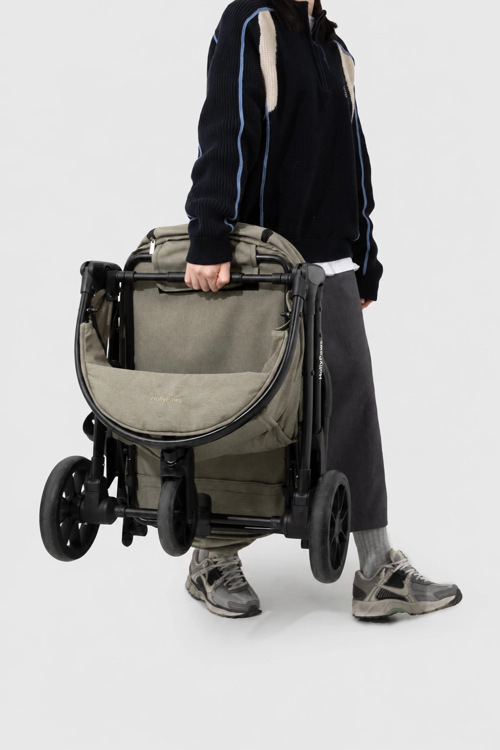 Folded stroller held by its frame, with HollyPaws lettering