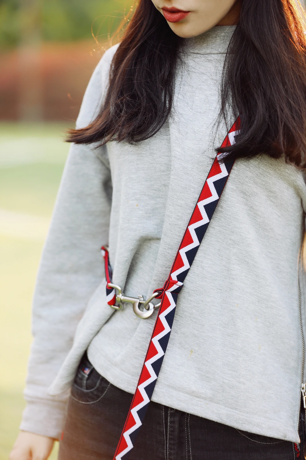 Red leash worn across the body showing a clip-to-ring configuration